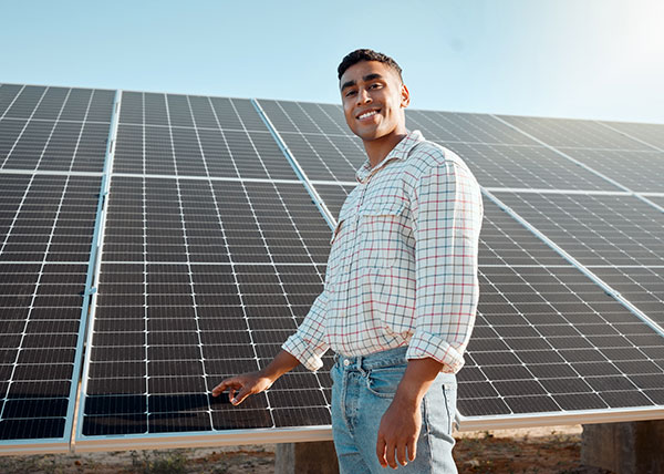 Hispanic man in front of solar panel